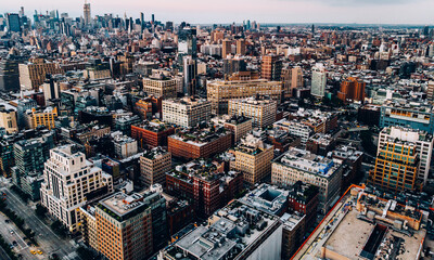Obraz premium Aerial view from helicopter sightseeing tour around Manhattan downtown district. Scenery bird's eye view with blocks of buildings leaving horizon. Metropolis with developed city urban infrastructure