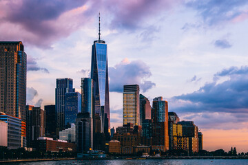 Panoramic view of Manhattan Island with sunset reflection in glass buildings.Scenery skyline view of contemporary skyscrapers of downtown financial district in New York. Gold sunset over NYC cityscape