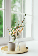 Vase with flowers and candles on the windowsill. March 8, Women's Day. Mother's Day. It's a beautiful romantic morning. Selective focus, spring summer seasonal concept