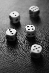 Dice squares on a black table. Bw photo.