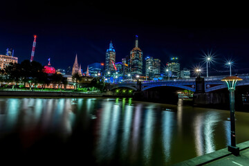Melbourne, Frankfurt - 05th March 2020: A german photographer visiting the city center and taking pictures of the skyline at night while walking along the river Yarra.