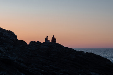 Disfrutando del atardecer en las rocas de la playa. Costa cantábrica. País Vasco. 