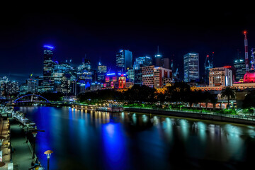 Melbourne, Frankfurt - 05th March 2020: A german photographer visiting the city center and taking pictures of the skyline at night while walking along the river Yarra.