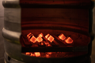 barbecue or hookah charcoals burning at metal barrel