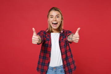 Excited funny young blonde woman girl in casual checkered shirt posing isolated on red background...