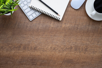 Wood office desk table with keyboard, notebook and coffee cup with equipment other office supplies. Business and finance concept. Flat lay with blank copy space, top view...