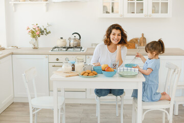 A young mother spends time with her little daughter at home.