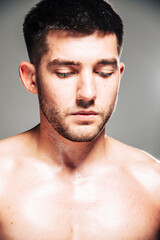 Lifestyle closeup portrait of attractive handsome shirtless young man posing in photo studio