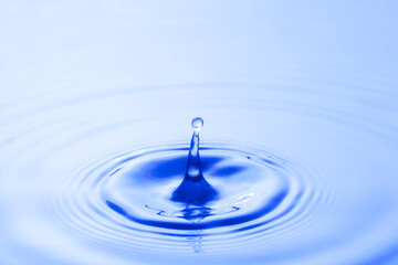 Water droplet falling impact with water surface. causing rings on water surface.