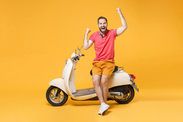 Overjoyed young bearded man guy in casual summer clothes standing near moped isolated on yellow...