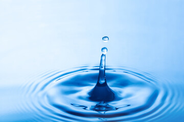Water droplet falling impact with water surface. causing rings on water surface.