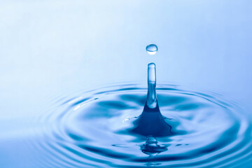 Water droplet falling impact with water surface. causing rings on water surface.