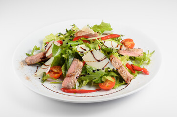 Striploin steak with grilled corn. Served on a white plate with a balsamic leaf and cherry tomato. For use in menu design and online delivery service. Can be used in a cookbook.