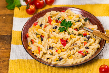 Cheesy Grilled Chicken Alfredo Pasta Florentine with Black Beans and Corn. Selective focus.