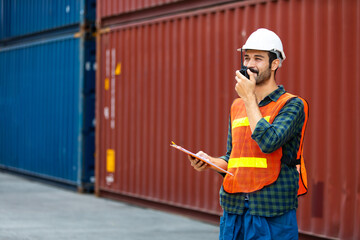 foreman maneger working through a radio communication with the workers in the container yard at...