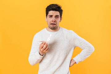 Photo of sick unhappy man with runny nose posing with tissue on camera