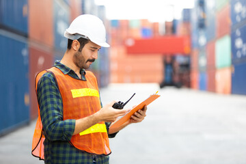 foreman maneger working through a radio communication with the workers in the container yard at port of import and export goods.
