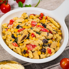 Cheesy Grilled Chicken Alfredo Pasta Florentine with Black Beans and Corn. Selective focus.