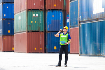 foreman maneger working through a radio communication with the workers in the container yard at...