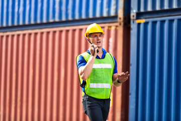 foreman maneger working through a radio communication with the workers in the container yard at port of import and export goods.