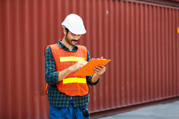 supervisor inspects wearing hardhat safety helmet working and checking control container shipping terminal at  shipping port for import and export