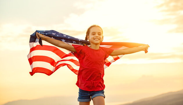 happy child girl with flag of united states enjoying the sunset on nature