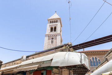 Fototapeta na wymiar The bell tower of Lutheran Church of the Redeemer rises above the ranks of the Arab Bazaar in the old city of Jerusalem, Israel