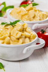 Parmesan Spinach Mac and Cheese on White Wooden Background. Selective focus.