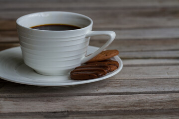 A cup of coffee and cookies on the wooden table