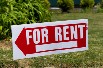 For rent sign shaped like an arrow in a yard