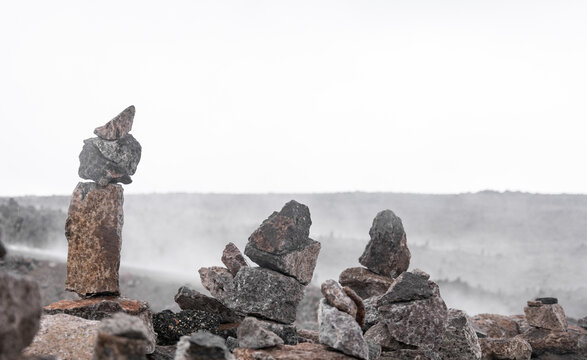 Close up of spiritual apachetas (stone stack) in beautiful misty scenery, near Arequipa, Peru.