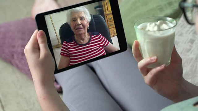 Young woman having video call via tablet talking to mom. Friends, facetime, online, internet, long distance communication, chatting concept. skype chatting with grandmother.