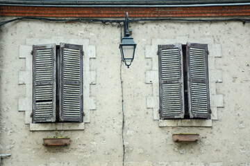 Fototapeta na wymiar closed shutters of two Windows and a lantern