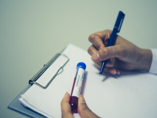 Concept of coronavirus blood test, Top view desk and hand of medical in laboratory and blood test tubes.
