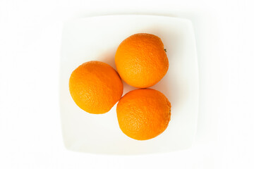 Oranges on a plate. Orange on a white background.