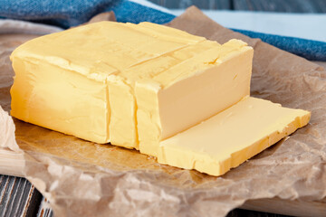 Cut butter on plate with blue towel on kitchen table