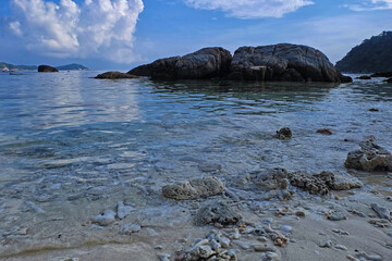 Landscape view of a beach filled with beautiful corall in a bright sunny day and blue sky condition