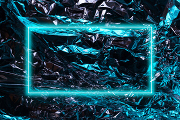 Shiny metal surface of aluminum rumpled foil with blue highlights, abstract background with neon...