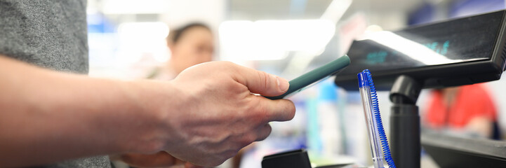 Man holding a smartphone in his store closeup