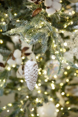 Christmas toy fir cone hanging on a branch of spruce. New year tree decorated with a garland