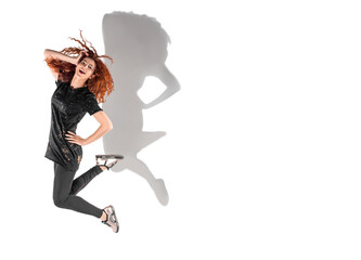 Isolated slender red-haired curly-haired girl in leggings and a T-shirt on a white background. A happy girl in a jump. Levitating girl snipe shot.