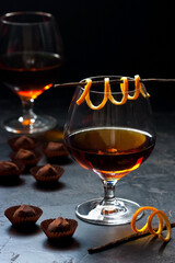 Whiskey or cognac  in  glass with  truffles candy on  dark background