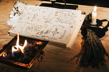 Occult white magic ritual of fire using grimoire, old book, candles