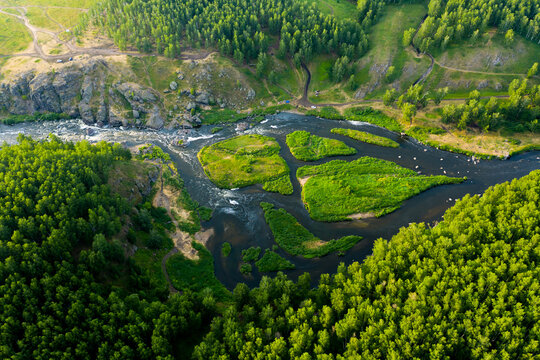 cascade of streams with Islands, green forests and grass, top view from drone, picturesque nature with mountain river in the forest.