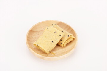 Crispy egg rolls with sesame seeds in a wooden bowl