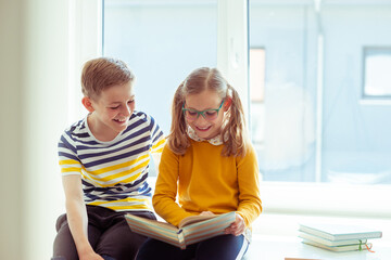 Fototapeta premium Two happy children reading funny book at holidays