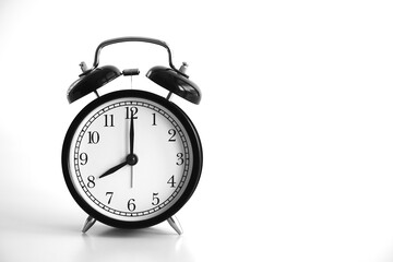 Black vintage alarm clock on table. White background. Wake up concept. An image of a retro clock showing 08:00 pm/am. 