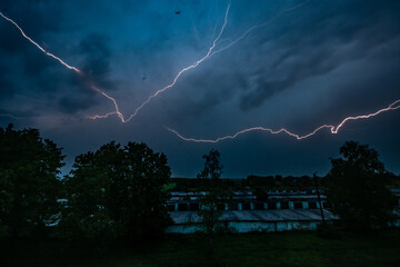 Stormy weather. Bright lightning across the dark sky.