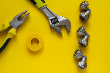 Adjustable wrench, pliers, PTFE tape and three bronze corner fittings for multilayer water pipes.