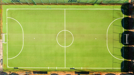Aerial view of a soccer field with synthetic grass during a sunny day